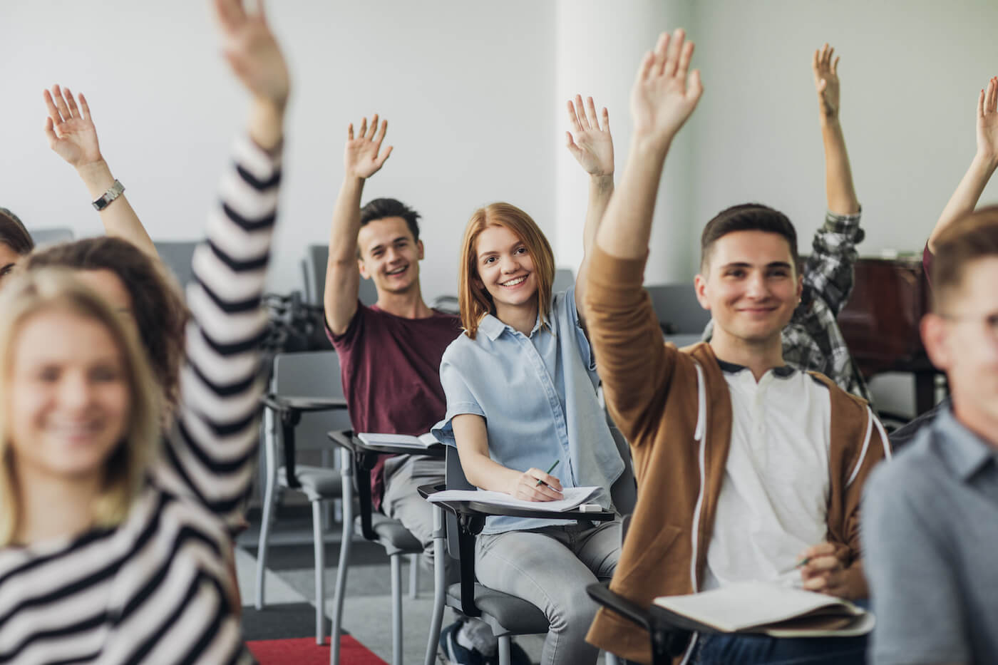Students raising their hands to answer in a GradeUP classroom.